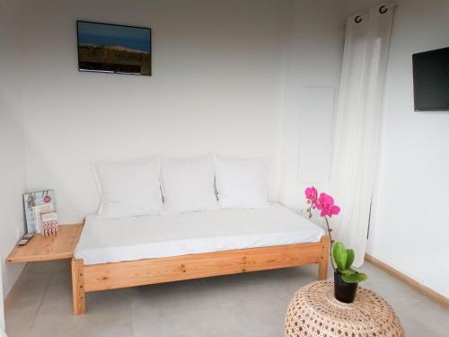 - une chambre avec un lit et un vase avec une fleur dans l'établissement Gîte accessible avec spa privatif et terrasse - FR-1-786-73, à Fleurimont