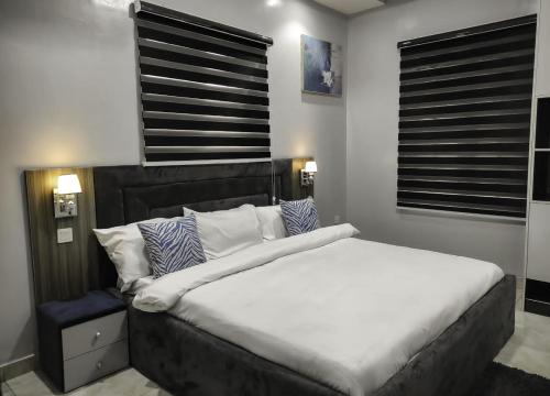 a bedroom with a large bed with white sheets and pillows at Abiluxe in Hausa