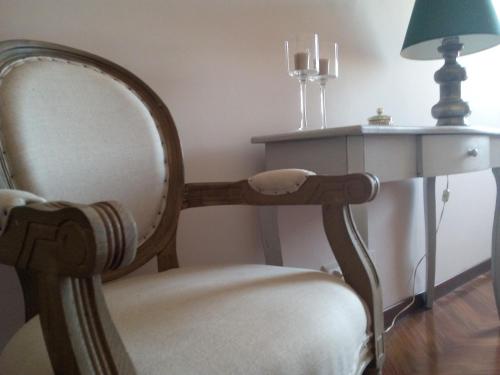 a chair sitting next to a table with a lamp at Il Silos in Maccarese