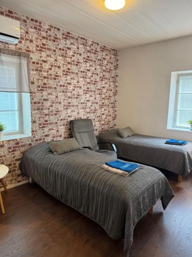 a bedroom with two beds and a brick wall at Gasthaus Sahanranta in Kuhmoinen