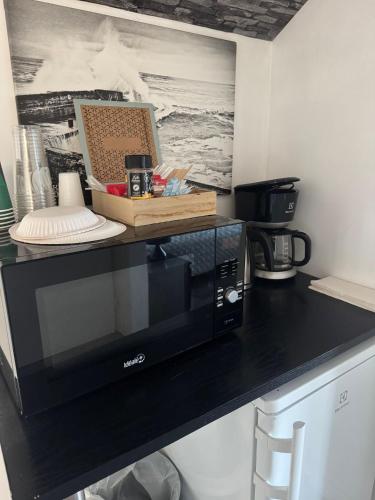 a black microwave sitting on a black counter top at Gasthaus Sahanranta in Kuhmoinen