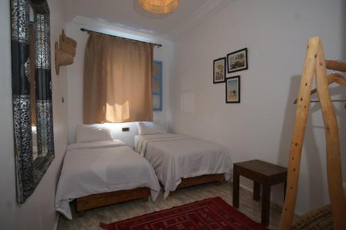 a bedroom with two beds and a window at Onda Surf in Taghazout