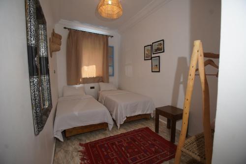 a bedroom with two beds and a window at Onda Surf in Taghazout