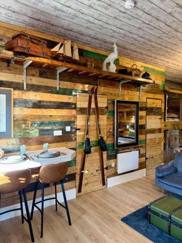 a room with a wooden wall with a table and chairs at Willow Court Farm-Studio North & Petting Farm, 8 mins from Legoland & Windsor, 15 mins from Lapland UK in Windsor