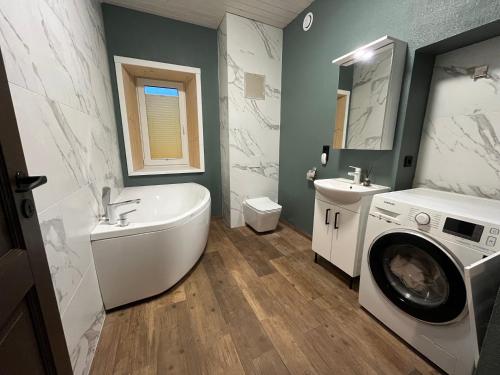 y baño con bañera y lavadora. en Ulila Kesk 13, 