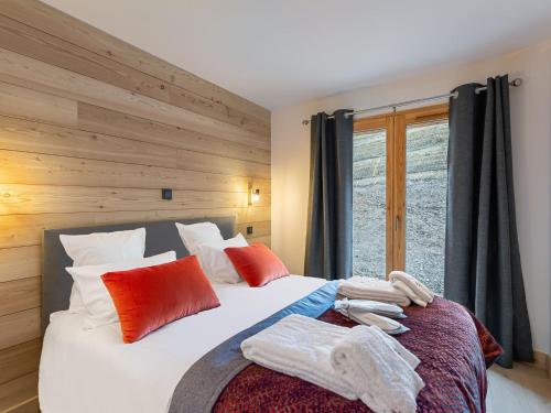 a bedroom with a bed with red and white pillows at Appartement pour 6 avec jacuzzi et vue panoramique - FR-1-570-33 in Saint-Martin-de-Belleville