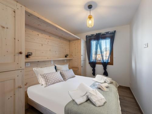 ein Schlafzimmer mit einem großen weißen Bett und einem Fenster in der Unterkunft Appartement au pied des pistes - 6 adultes + 2 enfants, 4 chambres, parking, wifi - FR-1-570-40 in Levassaix