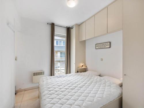Un dormitorio blanco con una cama grande y una ventana. en Klokjesbloem Gelijkvloers, en Galopen