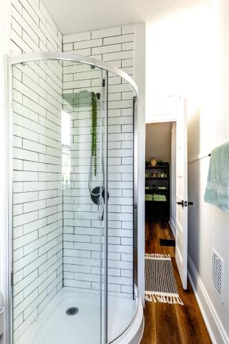 a walk in shower in a bathroom with white tiles at Short North Convention Private Parking Pets! in Columbus