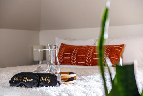 a pair of glass bottles sitting on a bed at Short North Convention Private Parking Pets! in Columbus
