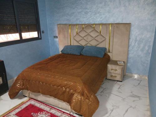 a bed with two blue pillows on top of it at Khenifra in Khenifra
