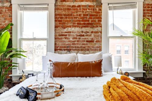 a bed in a room with a brick wall at Short North Convention Private Parking Pets! in Columbus