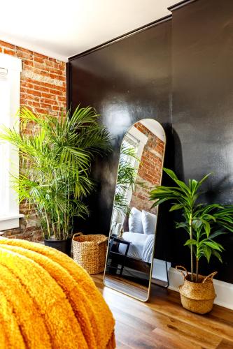 a mirror in a room with a bed and plants at Short North Convention Private Parking Pets! in Columbus