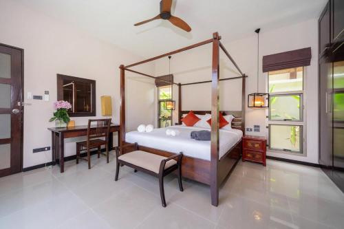 a bedroom with a canopy bed and a desk at 2 bedrooms pool and garden villa Niche 9 Rawai in Ban Nong Chaeng