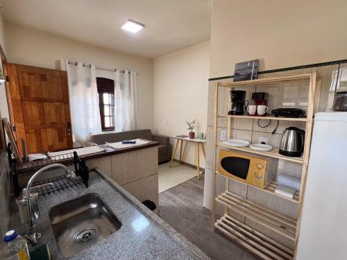 a small kitchen with a sink and a refrigerator at Casa Sabiá - Jaguariúna in Jaguariúna