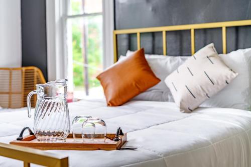 a glass pitcher on a tray on a bed at Short North Convention King Bed Free Parking! in Columbus