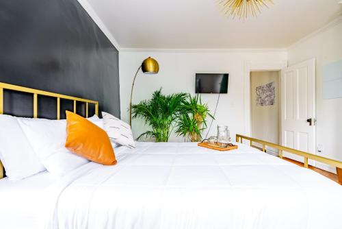 a bedroom with a large white bed with an orange pillow at Short North Convention King Bed Free Parking! in Columbus