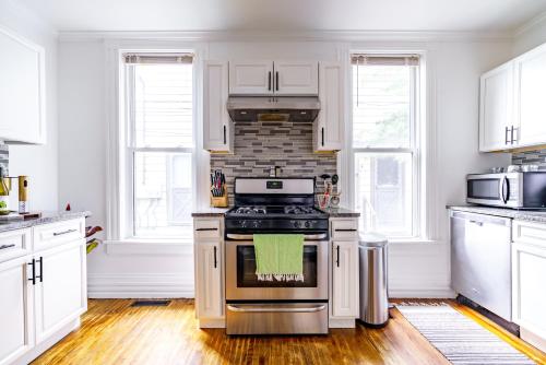 a kitchen with white cabinets and a stove top oven at Short North Convention King Bed Free Parking! in Columbus