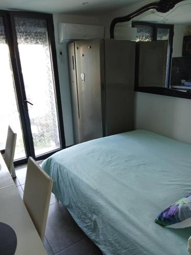 a bedroom with a white bed and two windows at STUDIO Perpignan in Perpignan