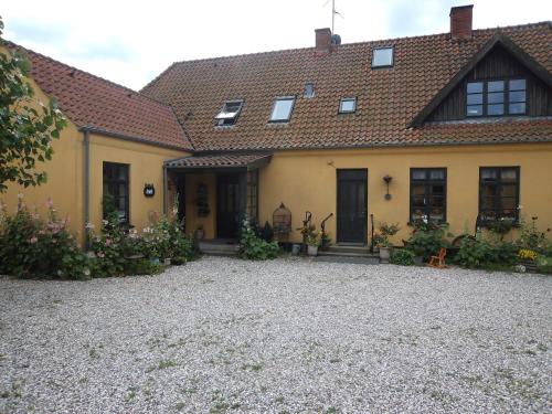 a large yellow house with a tile roof at Skovgården in Hillerød