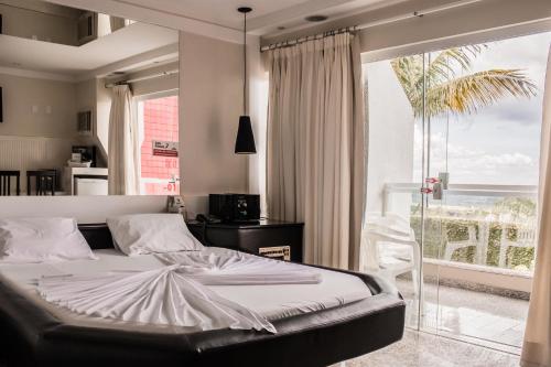 a bedroom with a bed and a large window at Motel Colorado (Adult Only) in Brasília