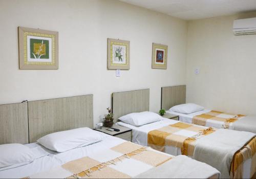 een kamer met drie bedden in een kamer bij Pousada Berro da Bode in Cabaceiras