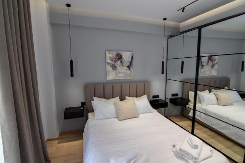 a bedroom with two beds and a mirror at twins luxury studios in Kastoria