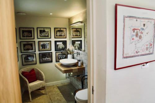 a bathroom with a sink and framed pictures on the wall at Charlbury country retreat - sleeps 10 in Charlbury