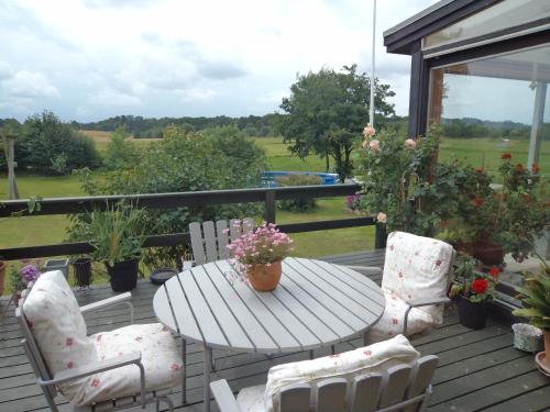 a wooden deck with a table and chairs on a porch at Skovgården in Hillerød