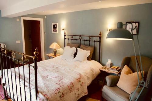 a bedroom with a large bed and a chair at Charlbury country retreat - sleeps 10 in Charlbury