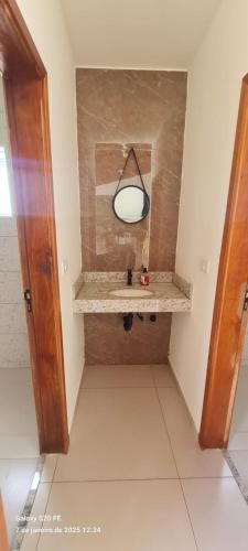 a bathroom with a sink and a mirror on the wall at La ville Guaxupe - Casa em Guaxupé in Guaxupé