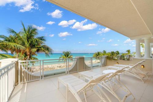 ジョージ・タウンにあるBeachcomber 11の椅子とビーチの景色が見えるバルコニー