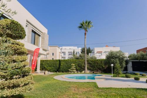 a villa with a palm tree and a swimming pool at Villa Oliviera in Akouda