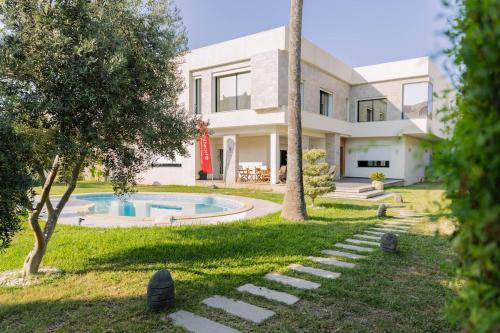 a house with a swimming pool in the yard at Villa Oliviera in Akouda