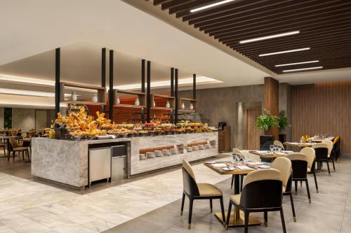 a restaurant with tables and chairs and a buffet at Movenpick Hotel & Residences Hajar Tower Makkah in Makkah