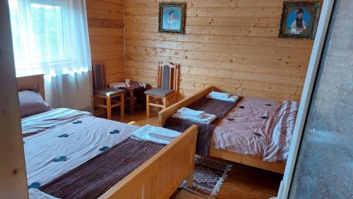 a bedroom with two beds and a table and chairs at Casa din deal-Apuseni 