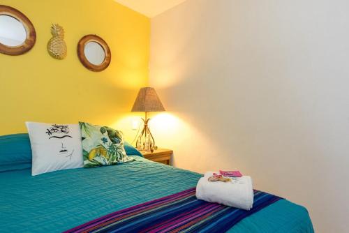 a bedroom with a bed and a lamp and mirrors at Ocean View 2BR Apt at Resort, 1 Block to the Beach in Puerto Vallarta