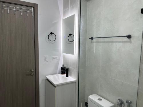 a white bathroom with a sink and a toilet at Seaview Comfort Studio in Panama City