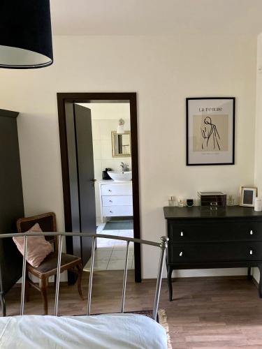 a bedroom with a bed and a dresser and a mirror at Rózsa Vendégház INGYENES PARKOLÁSSAL in Nagykovácsi