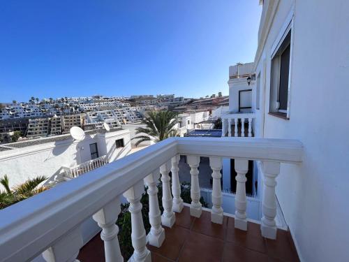 a white balcony with a view of the city at Malihana- Duplex con vistas y BBQ en Puerto Rico in Mogán
