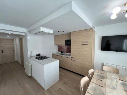 a white kitchen with a table and a dining room at Casa Collado Apartmento 2A in San Vicente