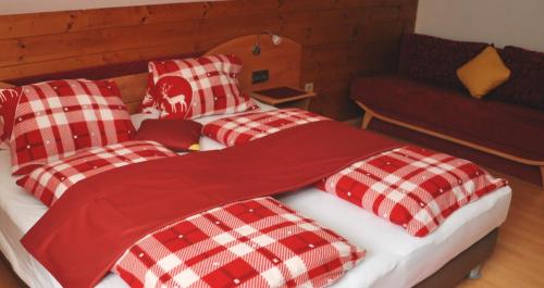 a bedroom with two beds with red and white checks at Gästehaus Biobauernhof Mandl in Murau