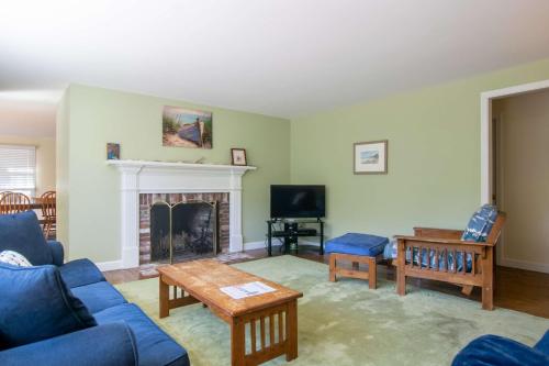 a living room with a blue couch and a fireplace at 1 6 mi to Nauset Beach in Orleans
