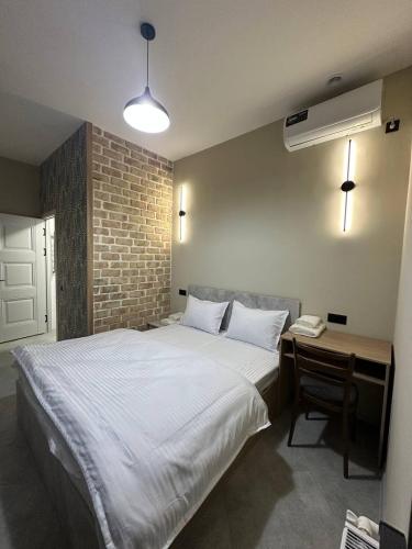 a bedroom with a large white bed and a desk at Begzod's Loft House in Samarkand
