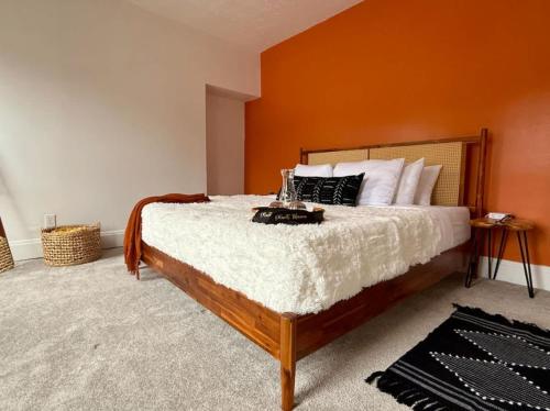 a bedroom with a large bed with an orange wall at Short North Convention King Bed Free Parking! in Columbus
