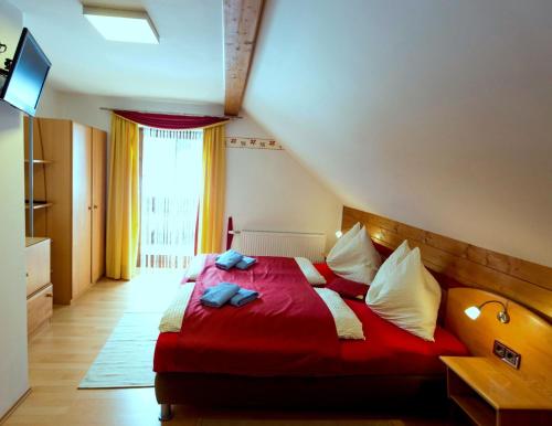 a bedroom with a red bed with towels on it at Gästehaus Biobauernhof Mandl in Murau