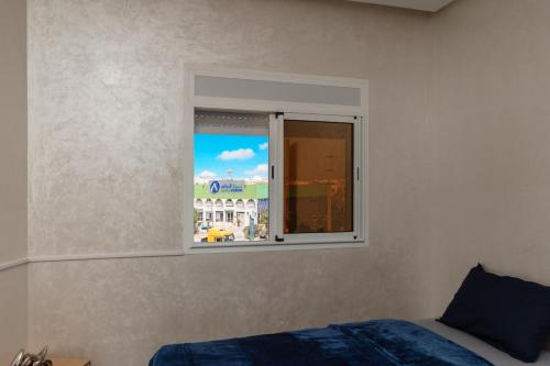 a bedroom with a window with a view of a building at Jaws Wave ESSAOUIRA in Ghazoua
