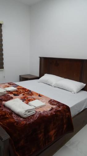 a bed with two towels on top of it at Petra Luminous Apartment in Wadi Musa