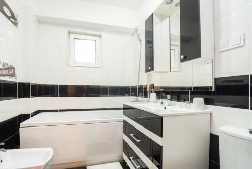 a white bathroom with black and white tiles at Apartament 21 in Craiova
