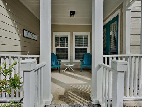 a porch of a house with two blue chairs at The Village #514 in Blue Mountain Beach